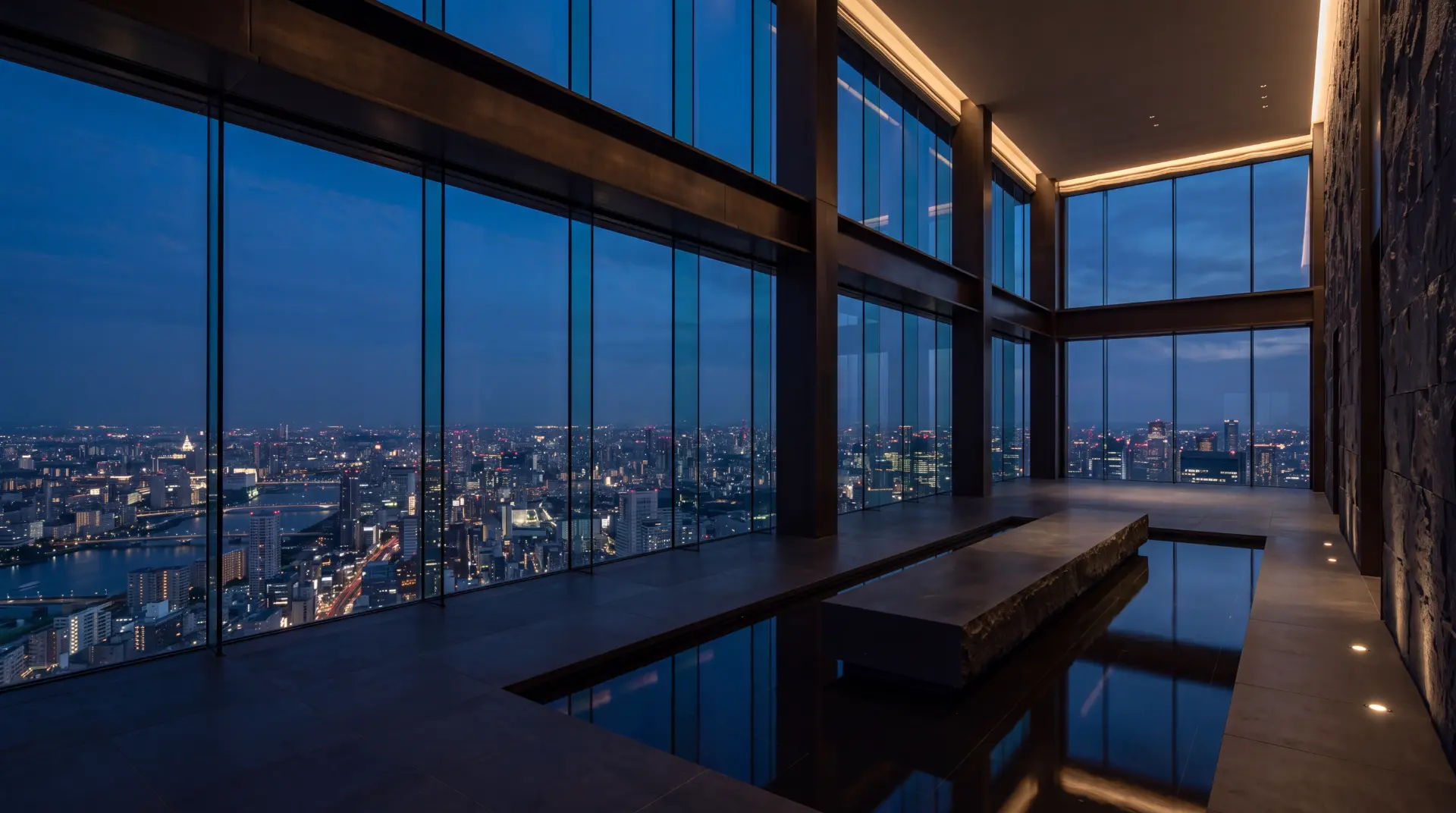 Glass-walled interior overlooking an illuminated city at night